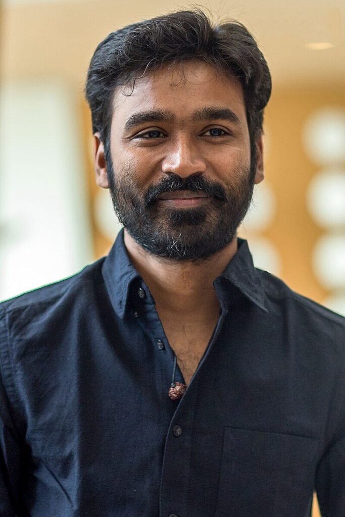 "Actor Dhanush smiling during his 42nd birthday celebration, highlighting his journey from local star to global icon."