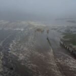 A dramatic depiction of an undersea earthquake near Russia's Kamchatka Peninsula with rising ocean waves and coastal tremors.